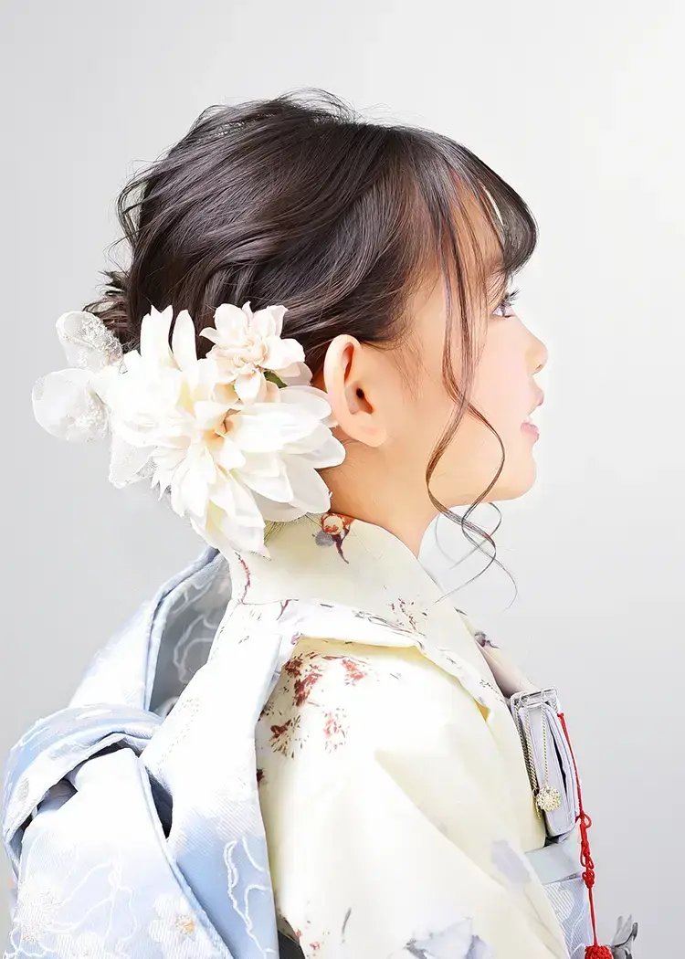 ふんわり甘めサイドシニヨンの右側。お団子のない方の面は大きな髪飾りで華やかに。