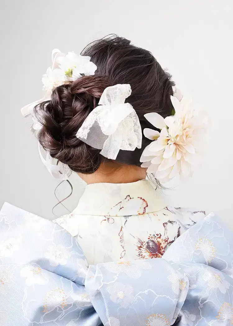 ふんわり甘めサイドシニヨンの後ろ姿。髪飾りは淡い色味で統一しておしゃれに